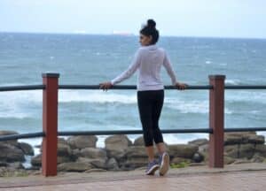 Femme mince en tenue de sport regardant la mer